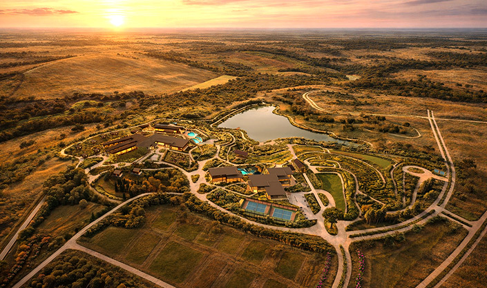 Aerial view of the Wildhaven Reserve master plan, with a lake, trails and clubhouse at sunset